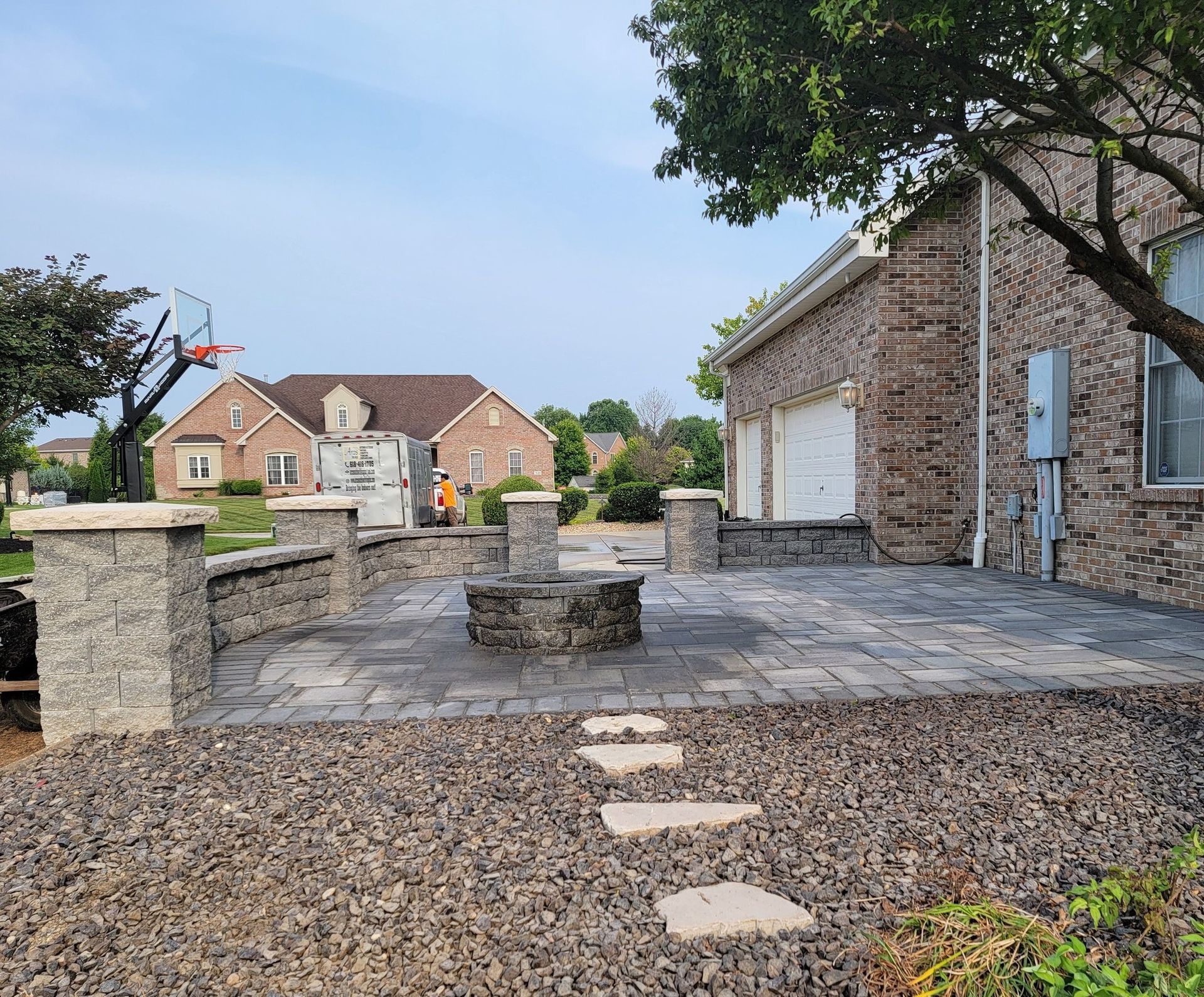 A brick house with a patio and a fire pit in front of it.