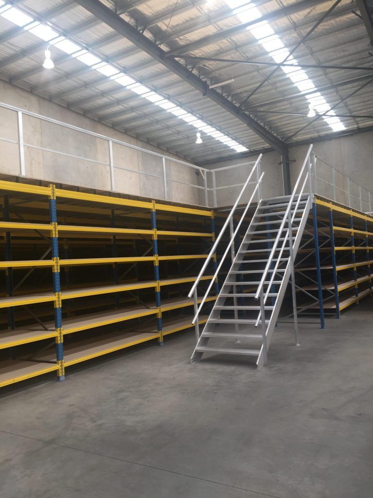 A warehouse with a staircase leading up to the second floor.