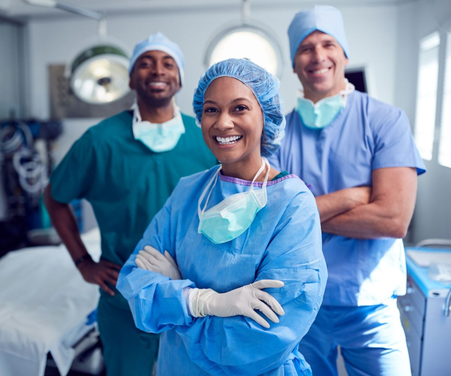 A group of surgeons are posing for a picture in an operating room.