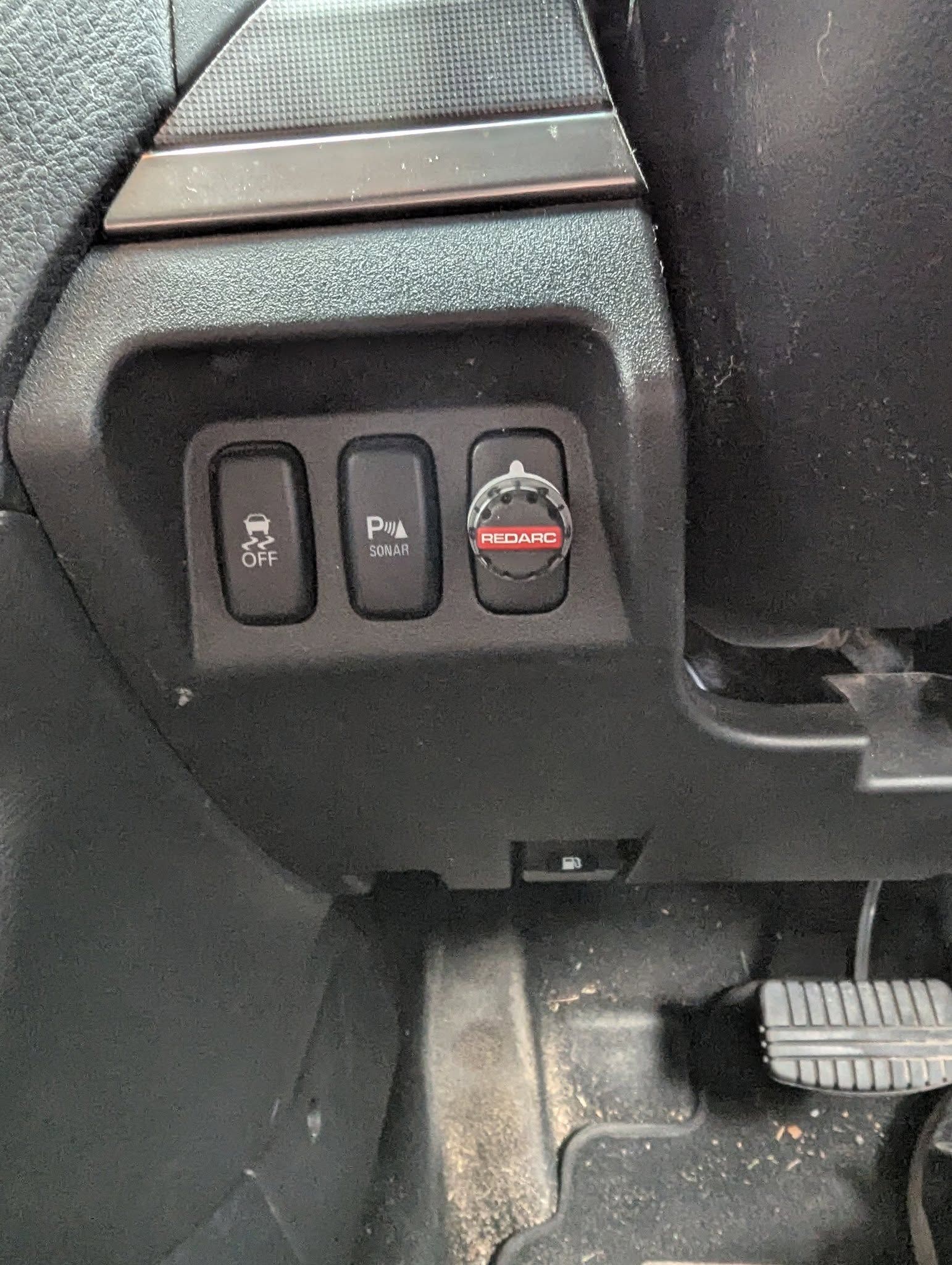 Dashboard buttons: traction control off, parking assist, and hazard lights on a car's lower panel. — Caravan and Trailer Clinic Geelong in Breakwater, VIC