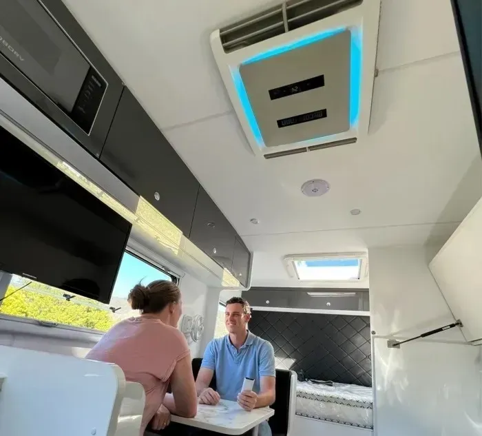 Couple Seated at a Table Inside a Caravan — Caravan and Trailer Clinic Geelong in Breakwater, VIC