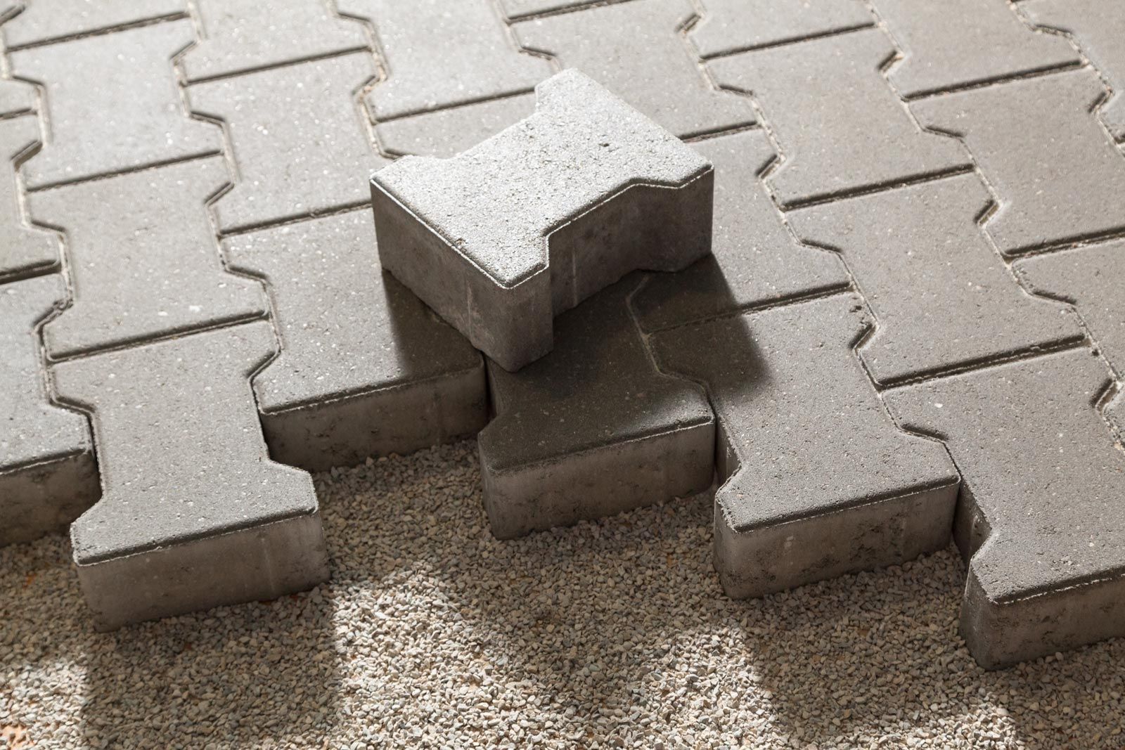 A pile of concrete pavers sitting on top of each other on the ground.