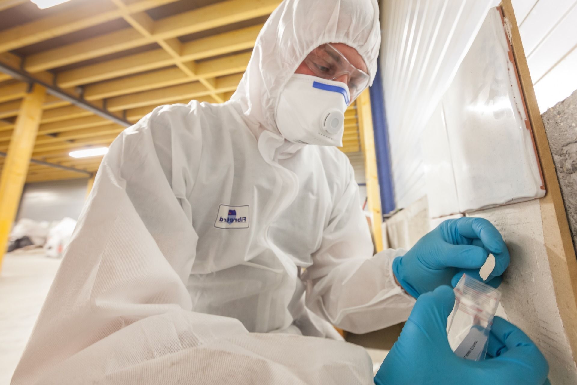 ARCO personnel in a protective suit and mask is conducting surface sampling for mold.