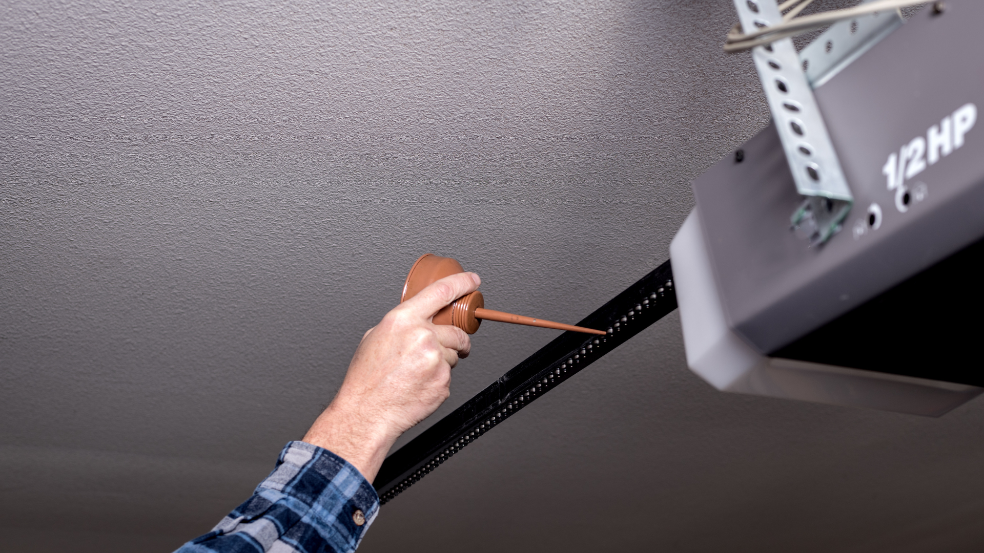 A person is measuring a garage door with a tape measure