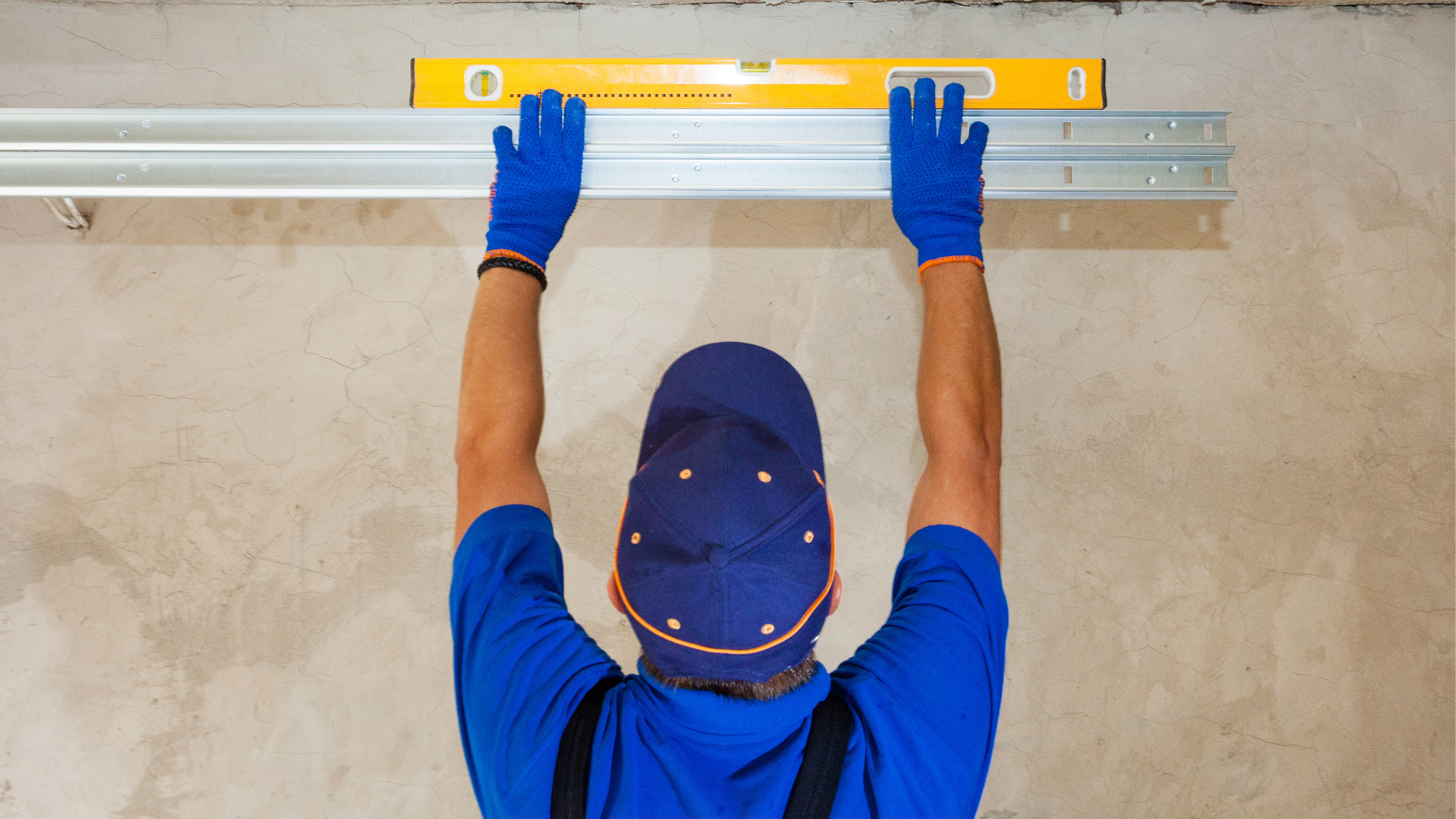 Homer's Garage Door Services technician leveling a garage door component.