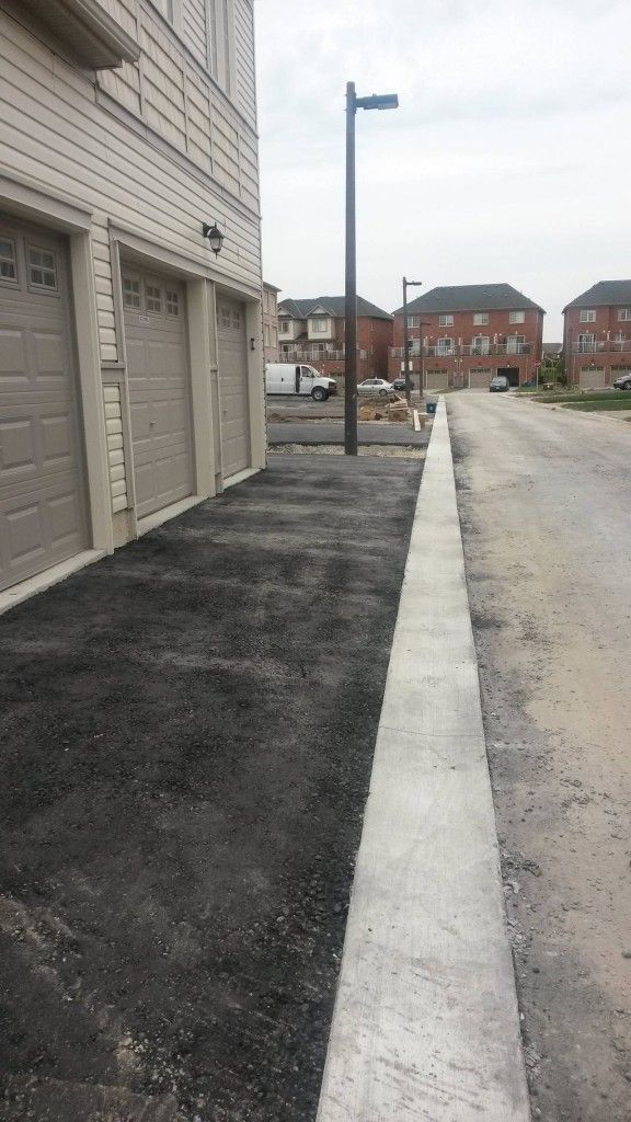 A row of garage doors next to a street in a residential area.