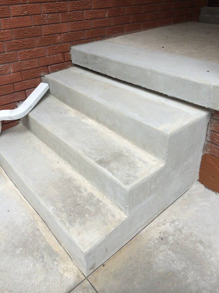 A set of concrete steps leading up to a brick building.