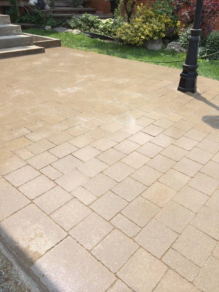 A brick walkway with a lamp post in the middle of it.