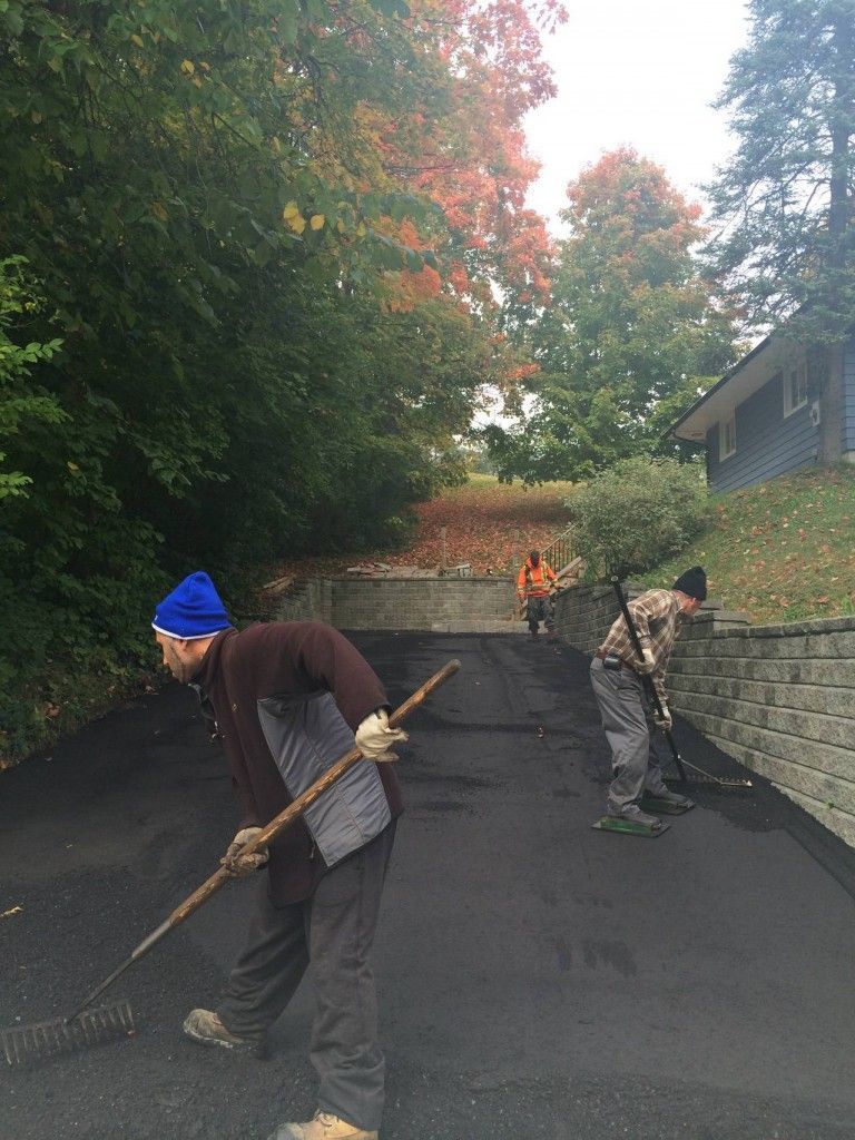 A group of men are working on a driveway.