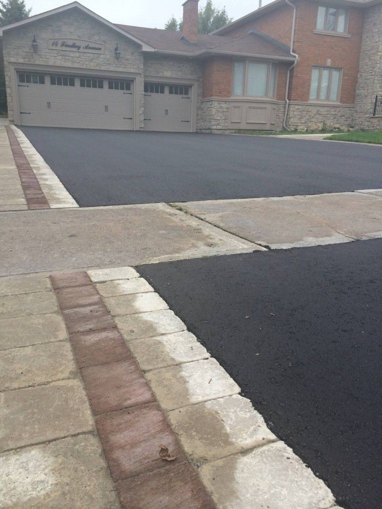 A house with a large driveway and a brick walkway.