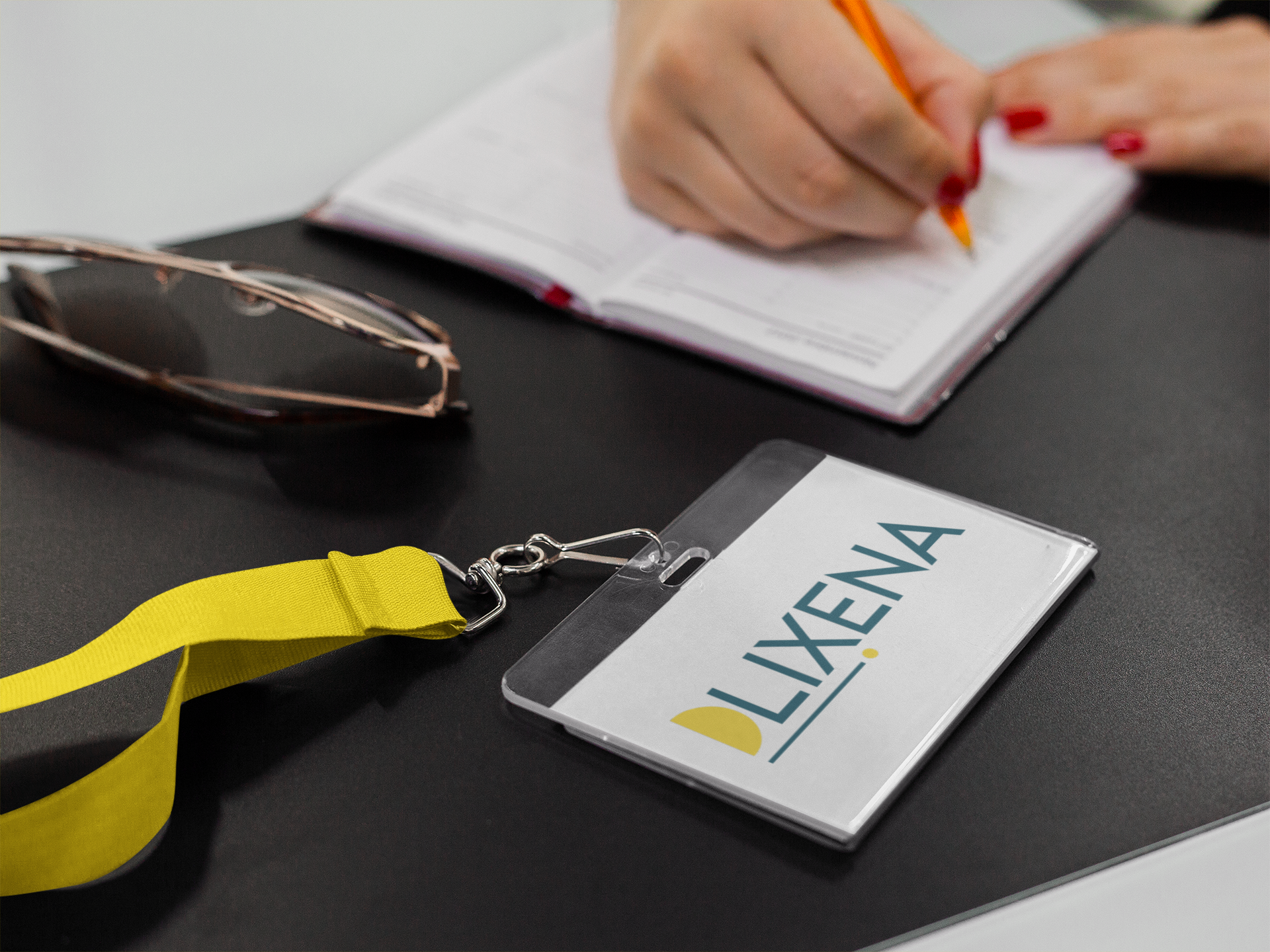 Une personne écrit dans un cahier à côté d'un cordon sur lequel est écrit lixena