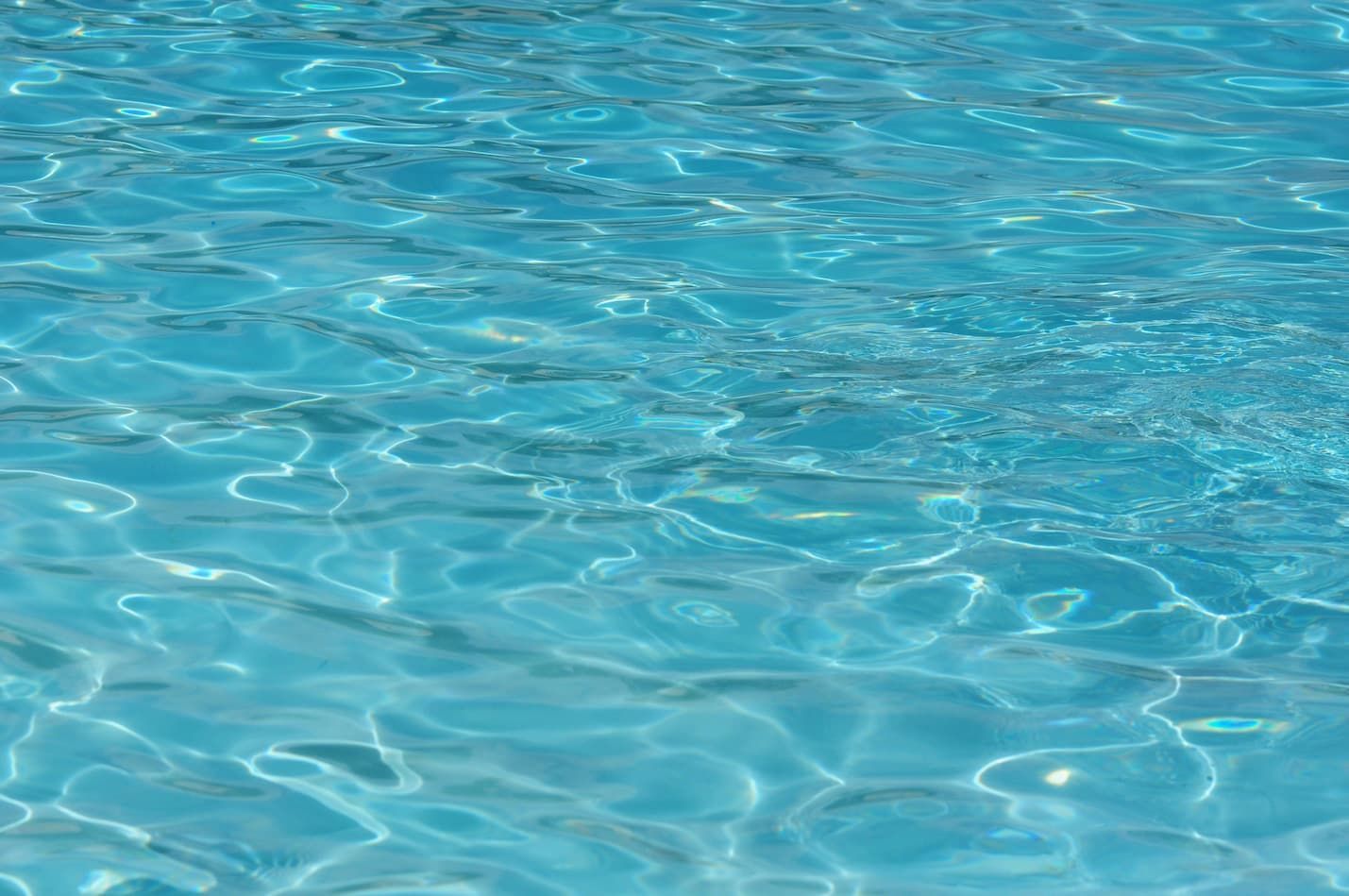 Clear blue rippling pool water reflecting sunlight