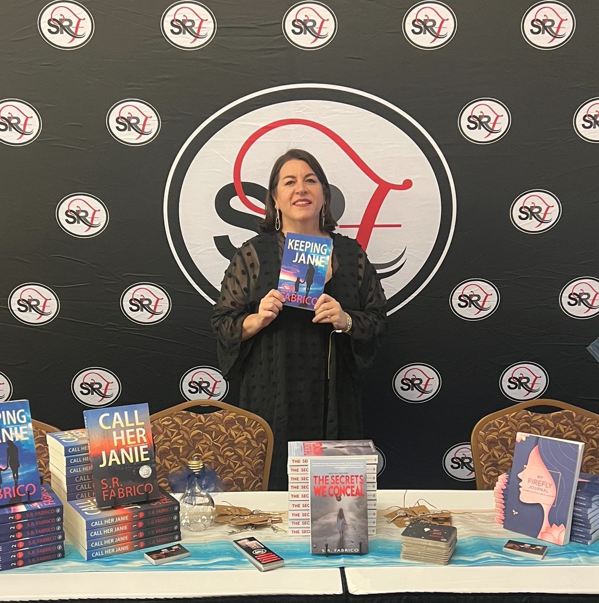 A woman is standing in front of a table holding a book titled call her jane.