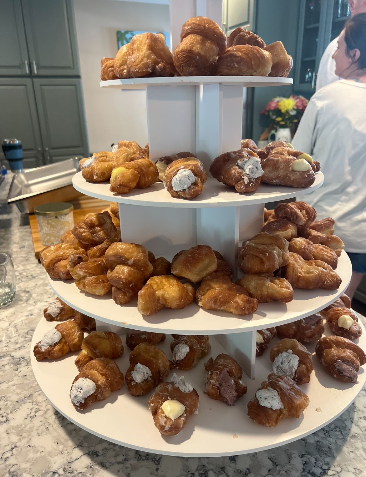 A stack of croissants and donuts on a table.