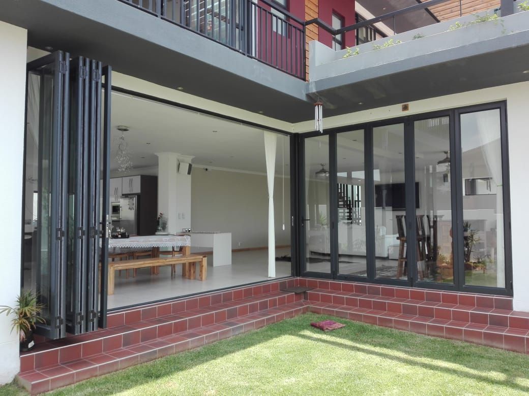 Windows in building with brick accents and grassy yard.