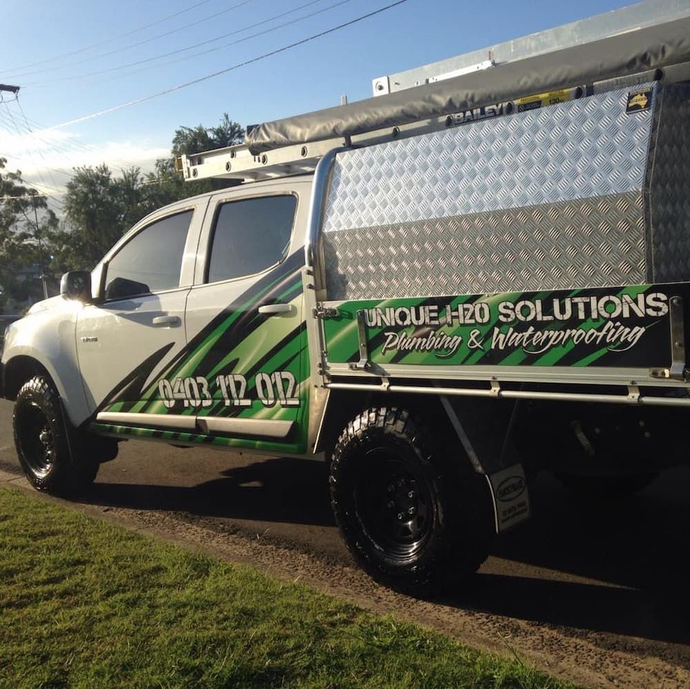 White Pickup Truck With Green Graphics — Unique Waterproofing Solutions in North Rocks, NSW