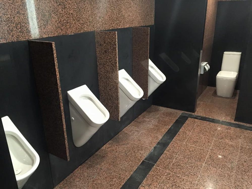 Public Restroom With Urinals and a Toilet Stall — Unique Waterproofing Solutions in North Rocks, NSW