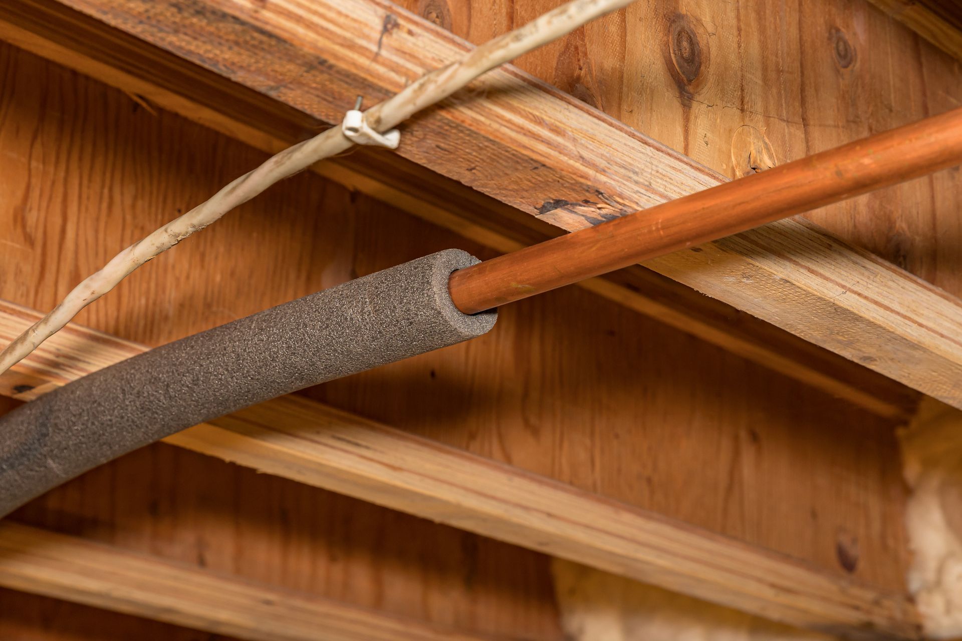 Water pipe with insulation in house installed by Evans Plumbing.