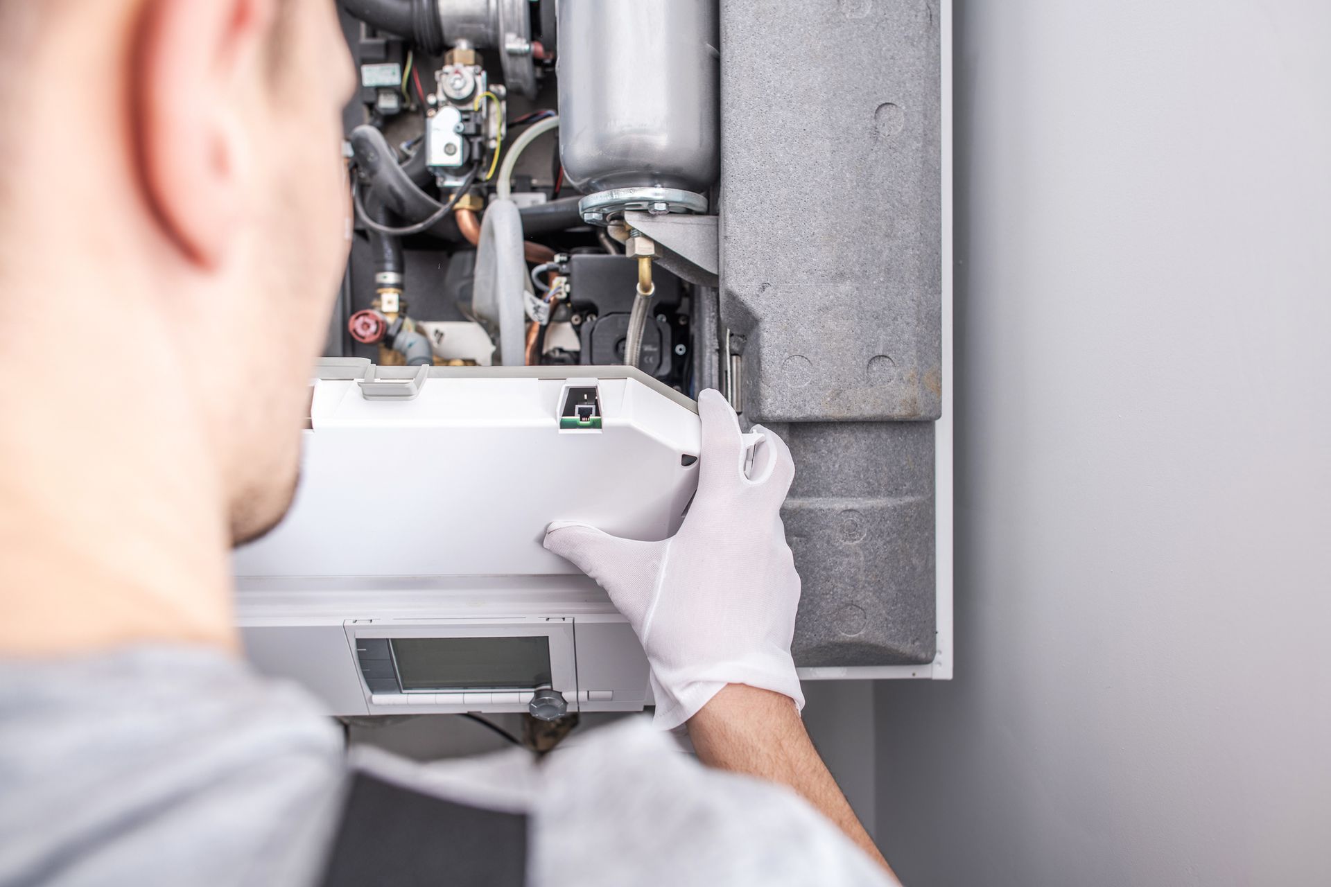 Evans Plumbing & Heating technician repairing a residential furnace during winter heating service.