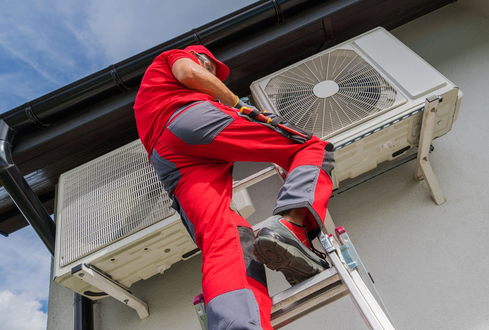 HVAC technician inspecting and servicing outdoor air conditioner at home in Endicott, New York.