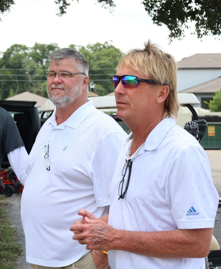 Two men are standing next to each other wearing white adidas shirts