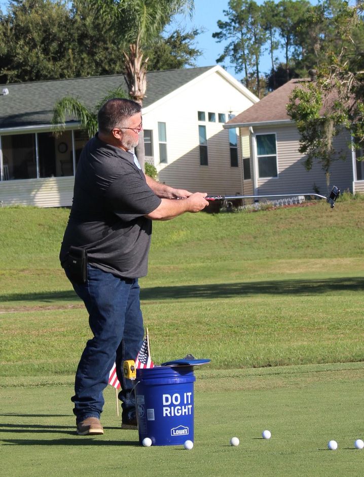 A man is standing next to a blue bucket that says do it right