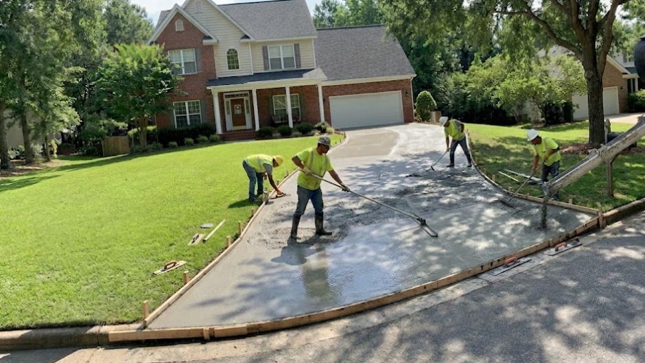 Professional concrete contractors pouring and smoothing a new concrete driveway in Summerville, SC.
