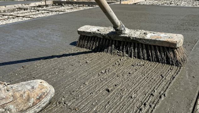 Creating a classic broom finish on a concrete sidewalk for safety and slip resistance.