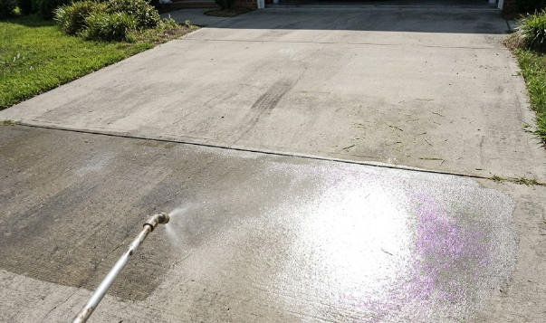 Protective sealant being applied to a concrete driveway for long-lasting maintenance.
