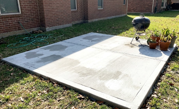 Classic broom finish concrete patio with a grill.