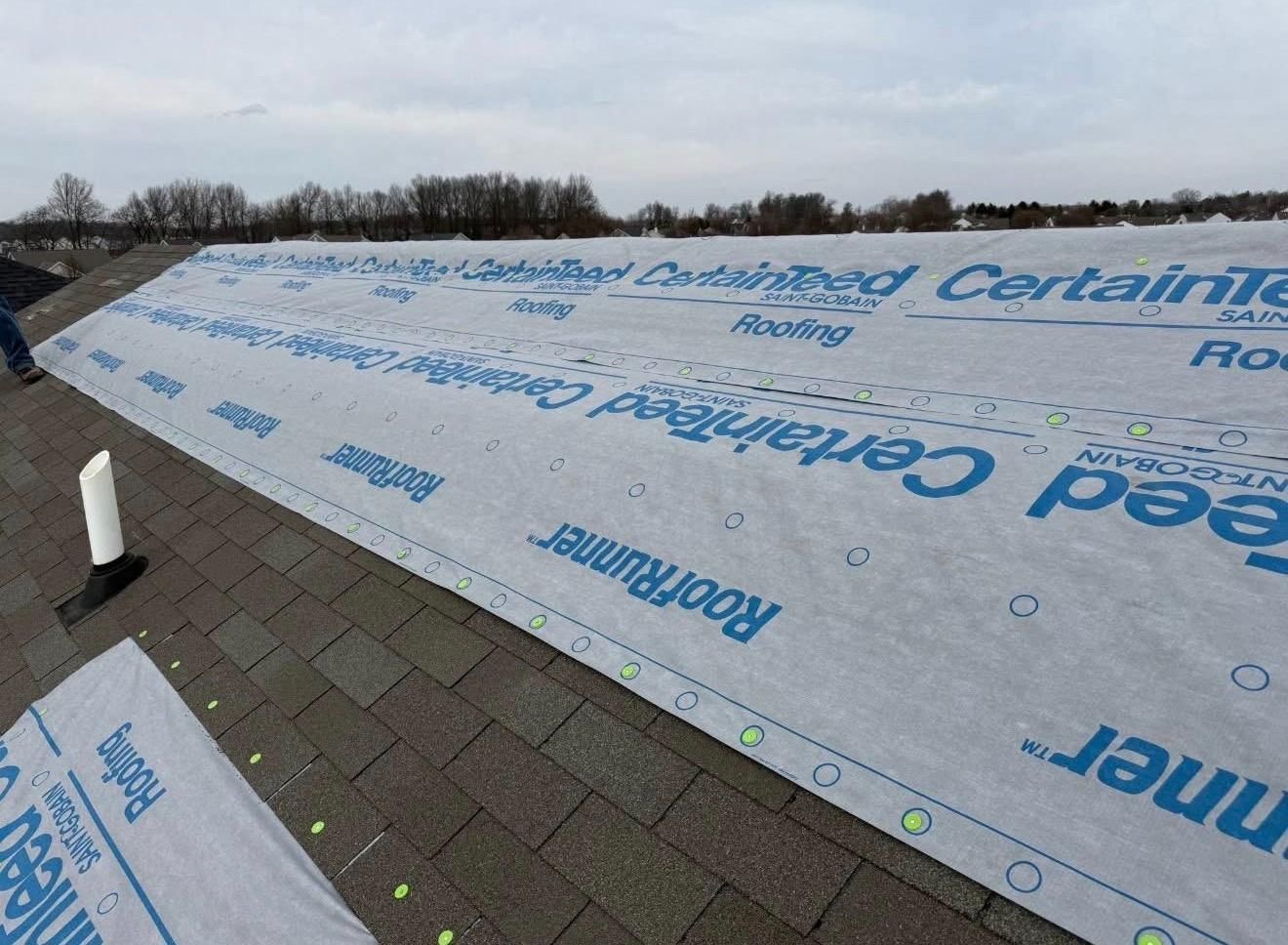 Roof underlayment installed over a sloped roof with a brick walkway in the foreground