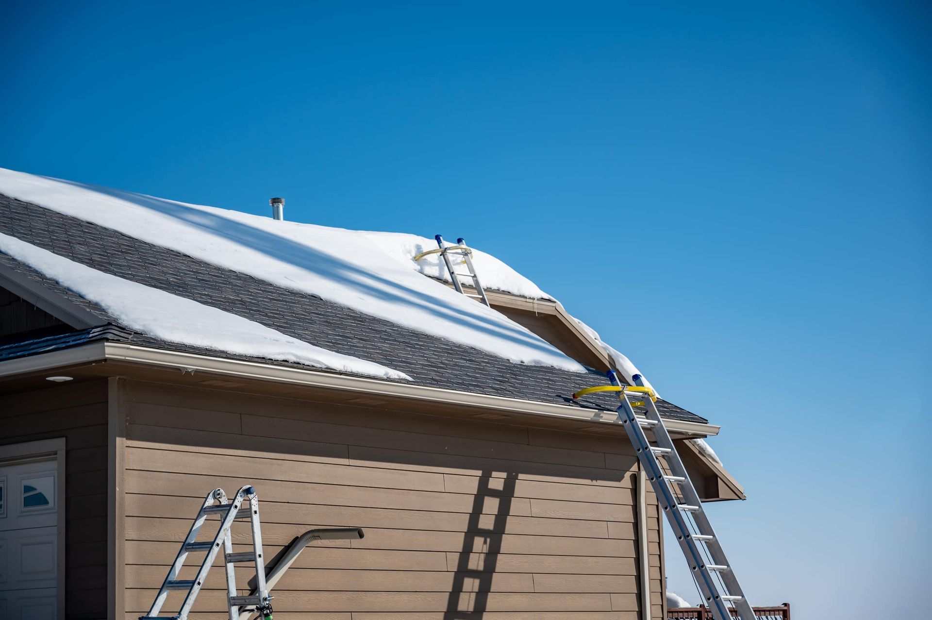 Ladder and roof under construction with blue sky overhead
