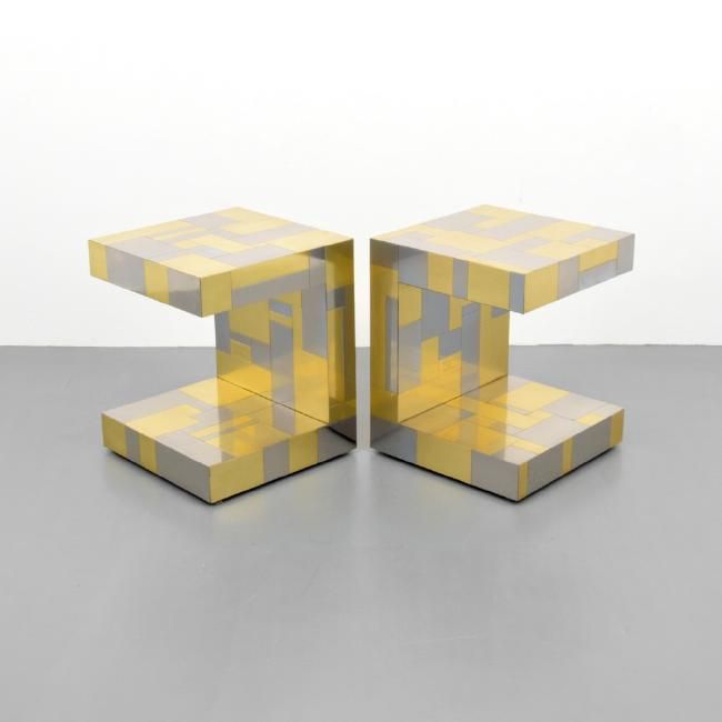 Two yellow-and-gray geometric stools or tables on a light gray floor against a white background