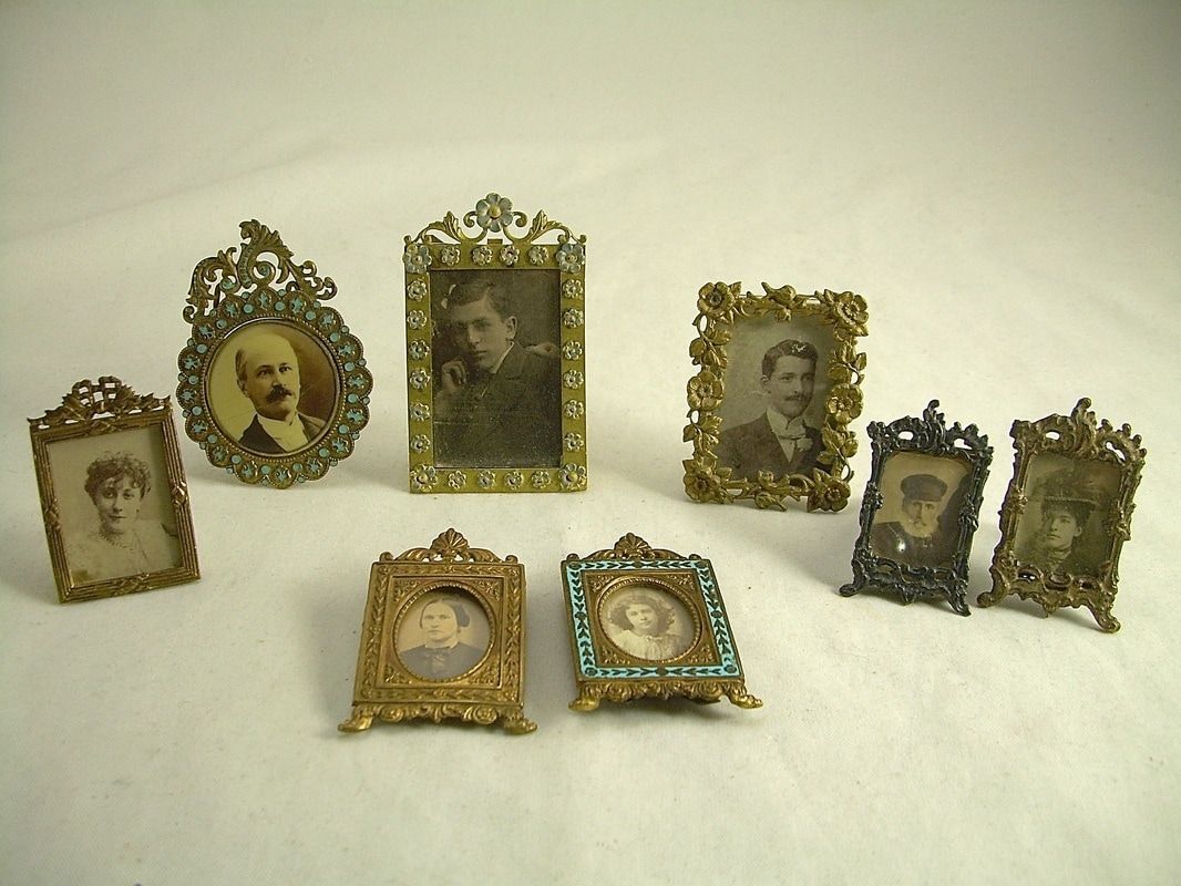 Assorted vintage framed portrait miniatures arranged on a white surface