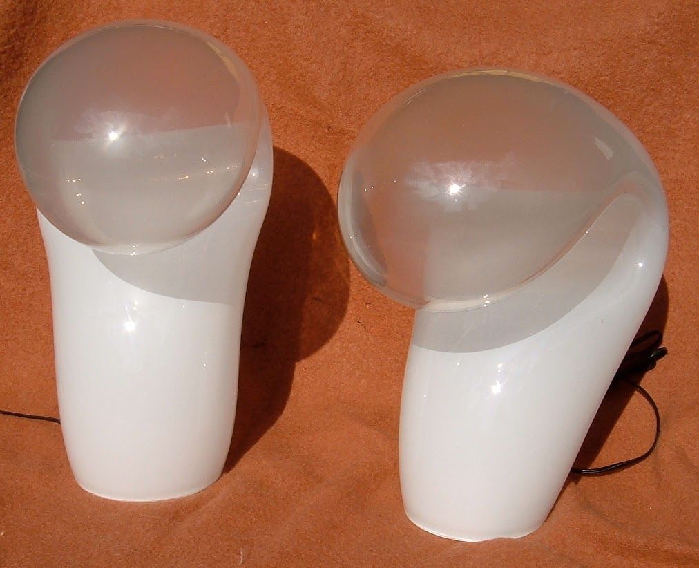 Two white-and-clear handheld devices on an orange surface, one with a black cord attached.
