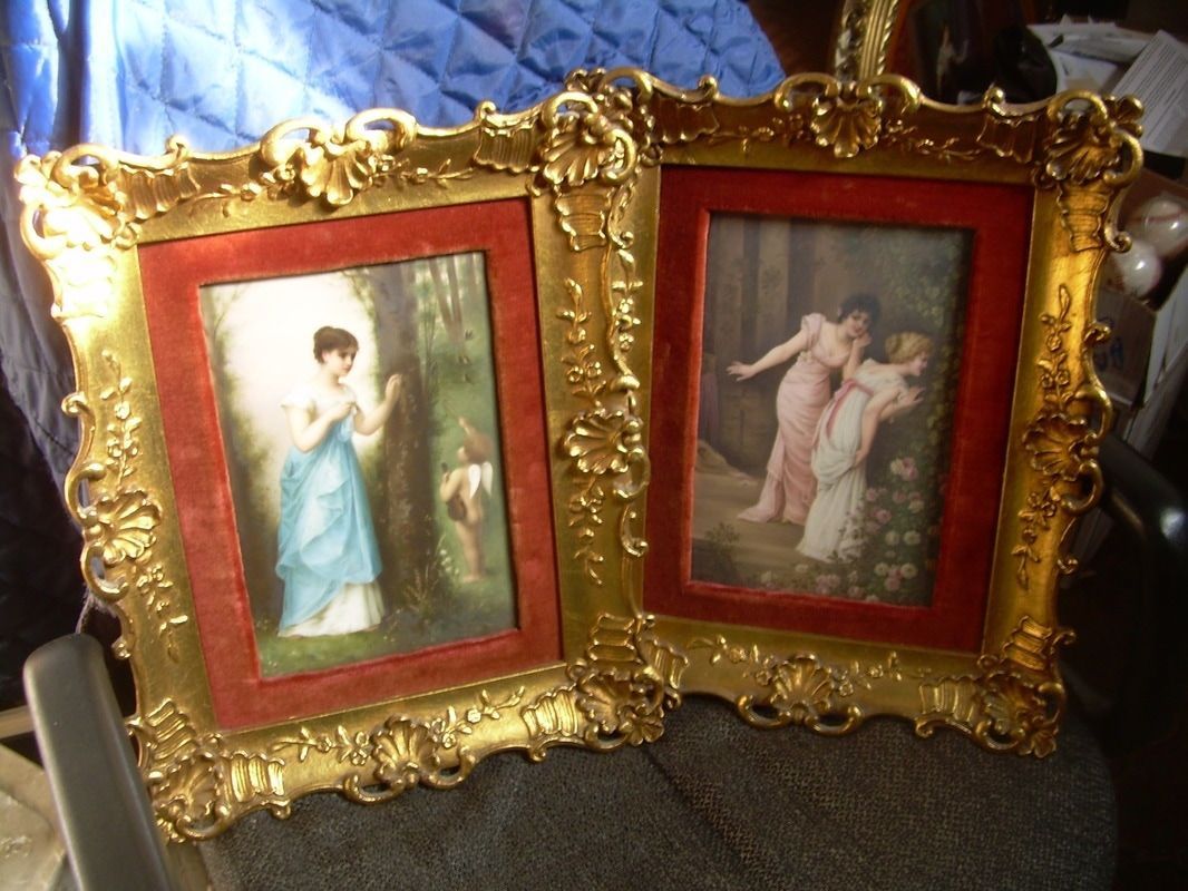 Two ornate gold picture frames with red mats, each holding a small classical portrait.