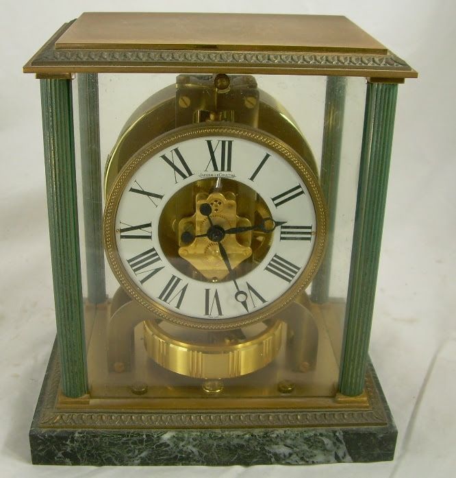 Brass and glass mantel clock with white Roman numeral dial and green columns