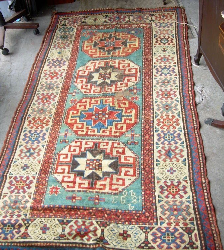 Colorful patterned oriental rug with red, teal, and cream geometric medallions on a floor