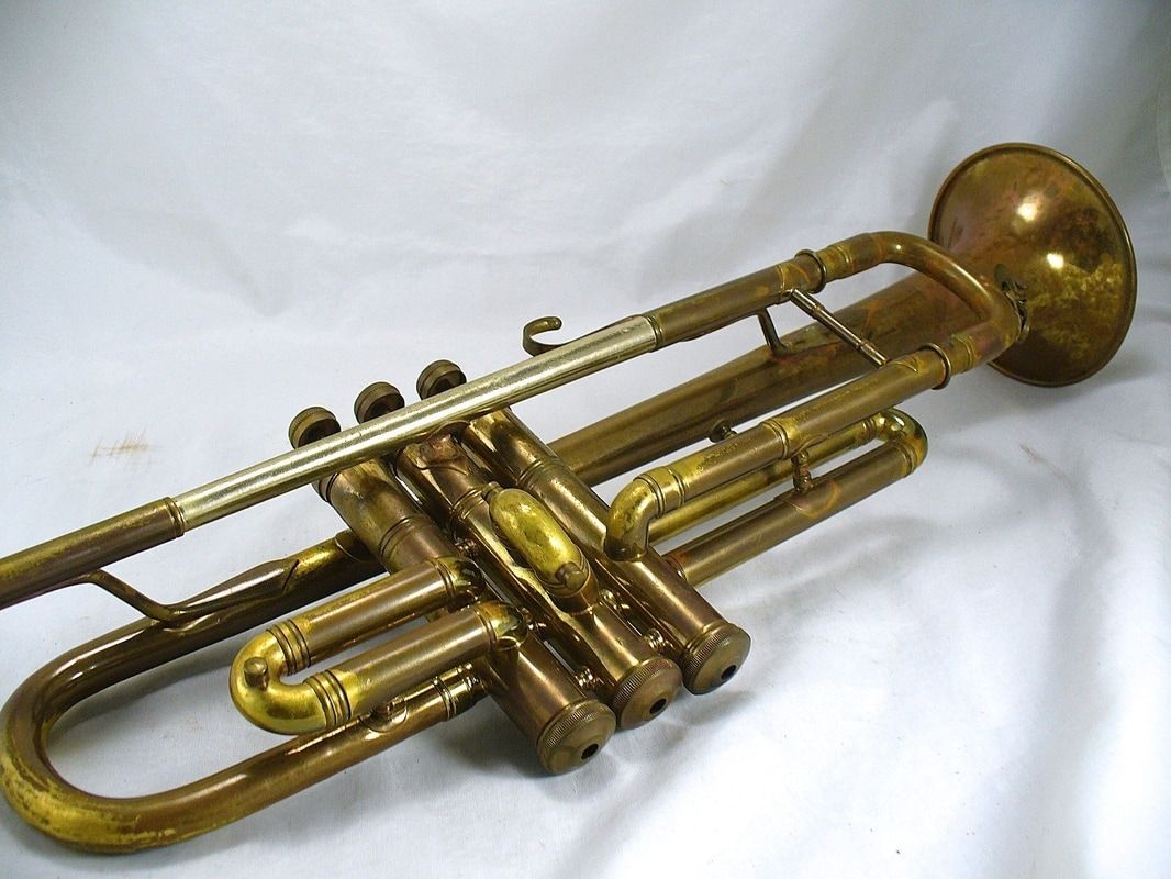 Brass trumpet lying on a white fabric background