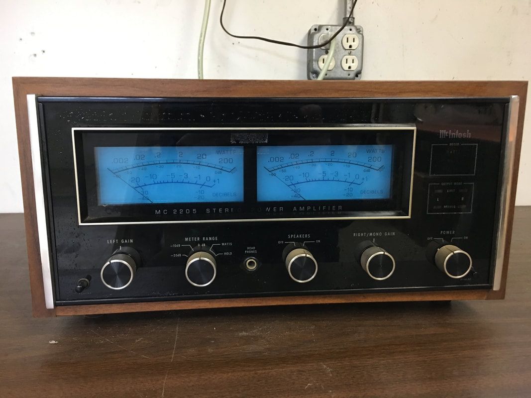 Vintage wooden tabletop radio with blue-lit tuning dial and control knobs on a table