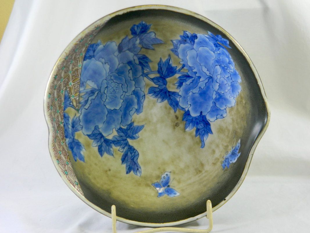 Blue floral ceramic plate on a stand against a light background