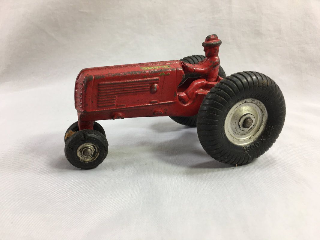 Red toy tractor with large rear wheel on a white background