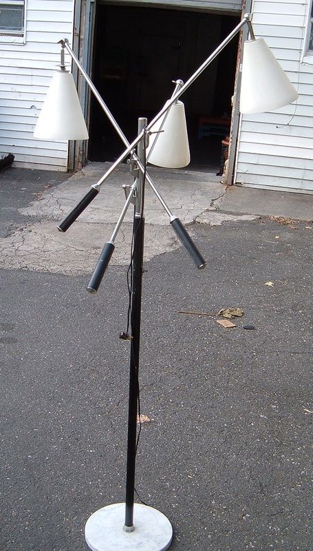 Metal stand with multiple angled black arms and white conical bags, set outdoors near a garage.