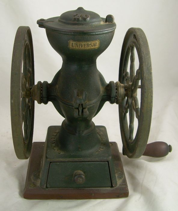 Vintage manual coffee grinder with metal wheels and wooden handle on a white background