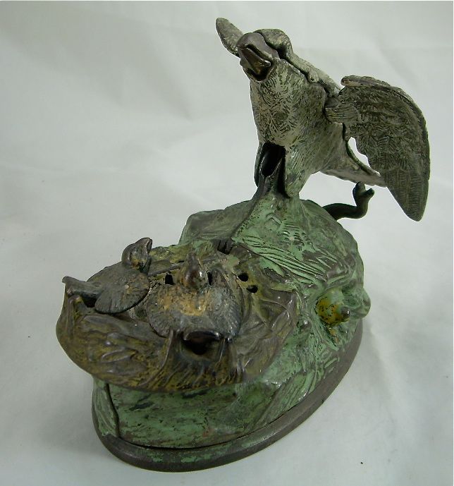 Small green metal sculpture of a bird perched on a textured base