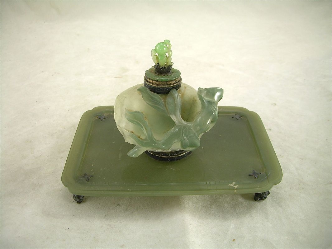 Small translucent green glass figurine on a rectangular green base
