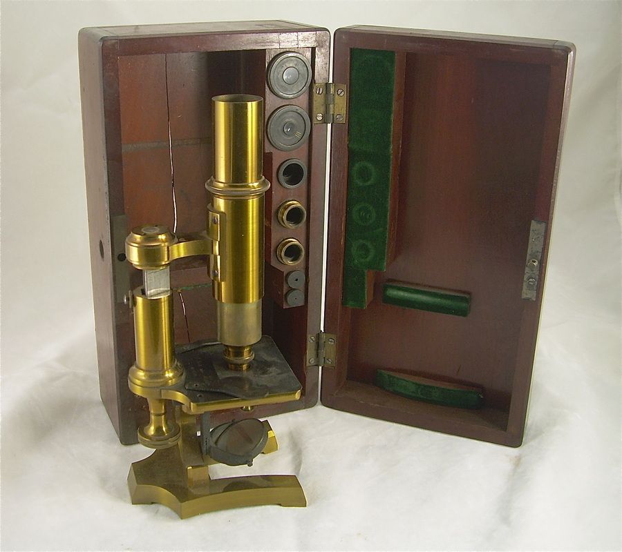 Antique brass microscope in a wooden display case with open lid