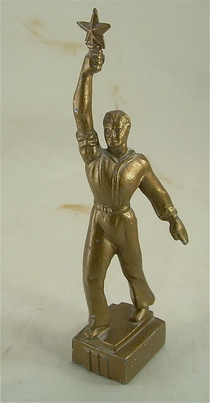 Gold-toned statuette of a person holding a star aloft on a rectangular base