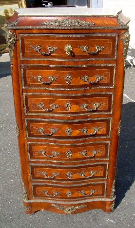 Ornate reddish-brown wooden dresser with multiple drawers and brass handles