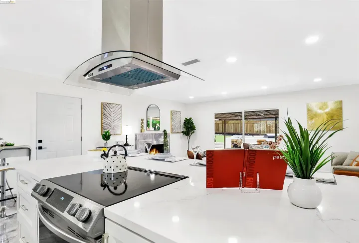 A kitchen with a stove top oven and a hood.